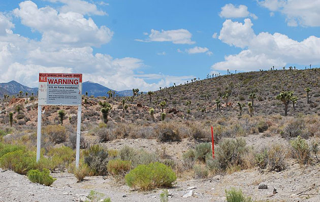 Ein Schild an einer Zufahrt zum als „Area 51“ oder „Dreamland“ bezeichneten militärischen Sperrgebiet von Groom Lake warnt vor dem unerlaubten Eindringen auf das Gelände. Copyright: Geckow / Gemeinfrei