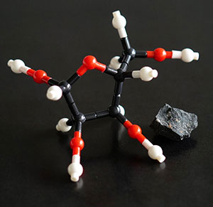 Ein Model der Molekülstruktur von Ribose neben einem Fragment des Murchison-Meteoriten. Copyright: Yoshihiro Furukawa